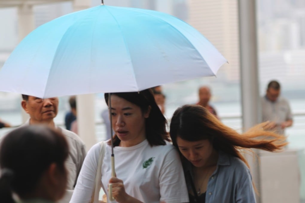 Pedestrians walk through the rain in Tsim Sha Tsui with typhoon signal No 3 in effect. Photo: Edward Wong
