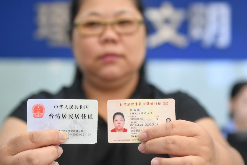 A Taiwanese woman shows off her new mainland residence permit (left). Photo: Xinhua