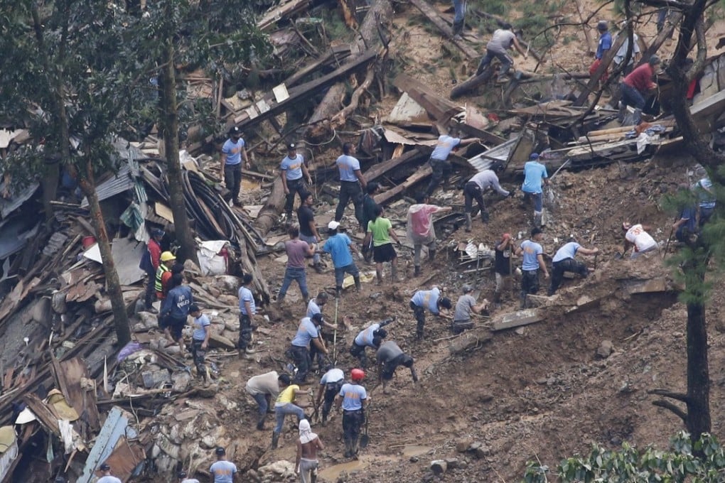 Rescuers search for people buried by a landslide in the village of Ucab, northern Philippines. Photo: AP