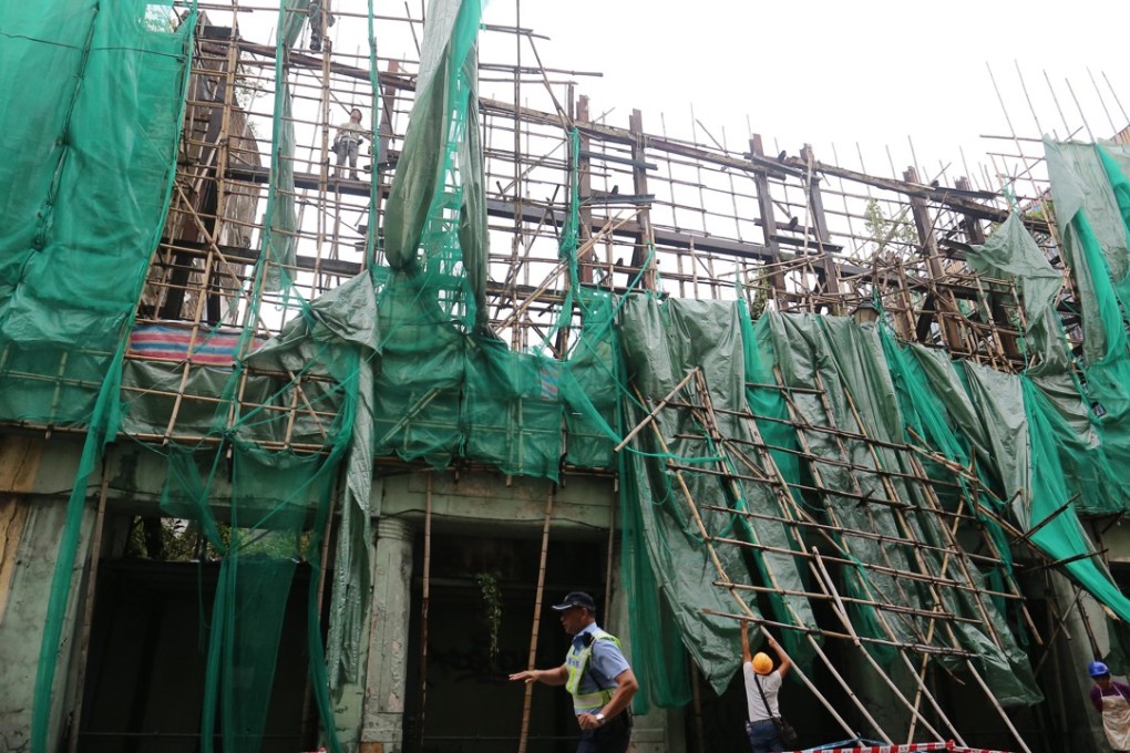 Workers are seen repairing scaffolding after the storm. Photo: Dickson Lee