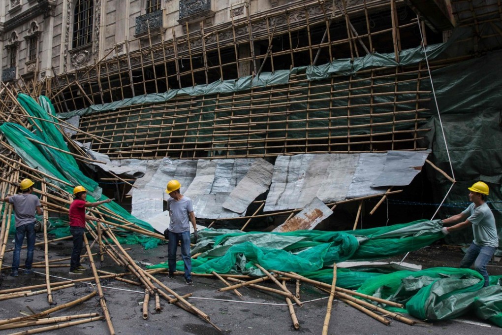 Bearing the brunt: Macau workers clear up scaffolding brought down by strong winds, a day after Typhoon Mangkhut hammered there, Hong Kong and southern China. Photo: AFP)