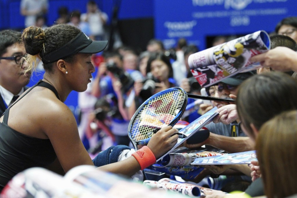 Japan’s Naomi Osaka signs her autograph to fans after defeating Dominika Cibulkova of Slovakia at Pan Pacific Open. Photo: AP