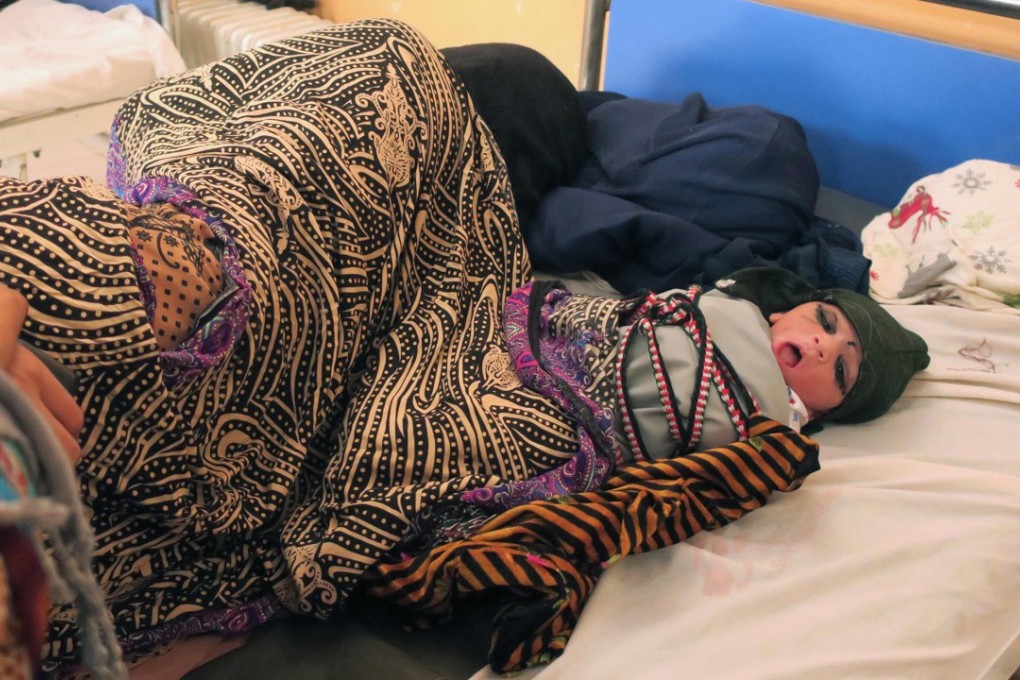 An Afghan woman rests next to her newborn baby at the Medecins Sans Frontieres maternity hospital in Khost Province, Afghanistan, one of the most active in the world, with more than 60 babies born daily. Photo: Anne Chaon/AFP