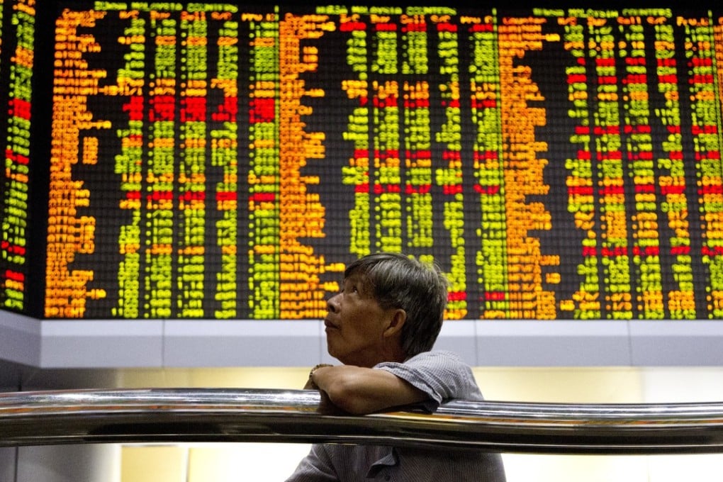 An investor sits in front of trading boards at a private stock market gallery in Kuala Lumpur, Malaysia, on September 13. Photo: AP
