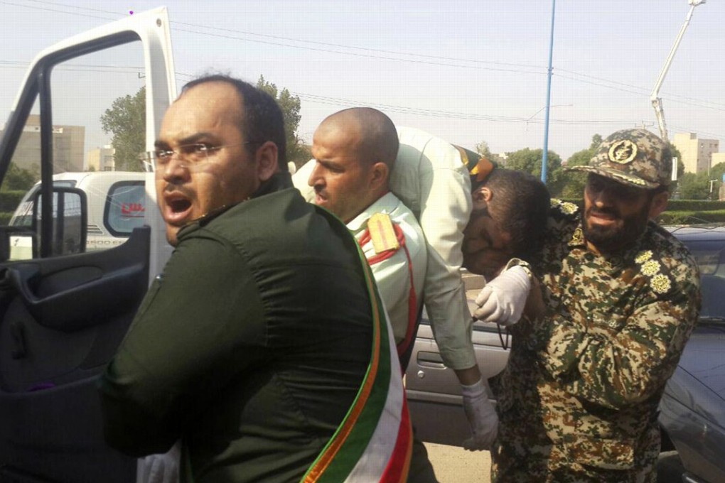 Revolutionary Guard members carry a wounded comrade to a car after the attack on a military parade marking the 38th anniversary of Iraq’s 1980 invasion of Iran. Photo: AP