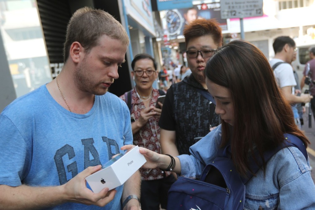 Parallel traders collect iPhones from customers outside the Apple store in Causeway Bay. Photo: Edward Wong