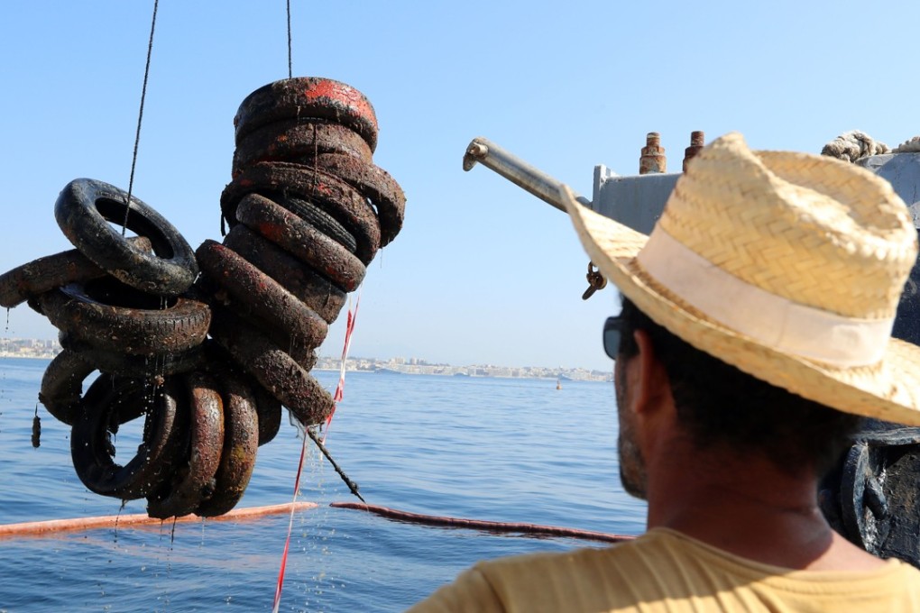Since the start of last week, divers and a specially equipped boat with lifting gear have been fishing out hundreds of tyres. Photo: AFP