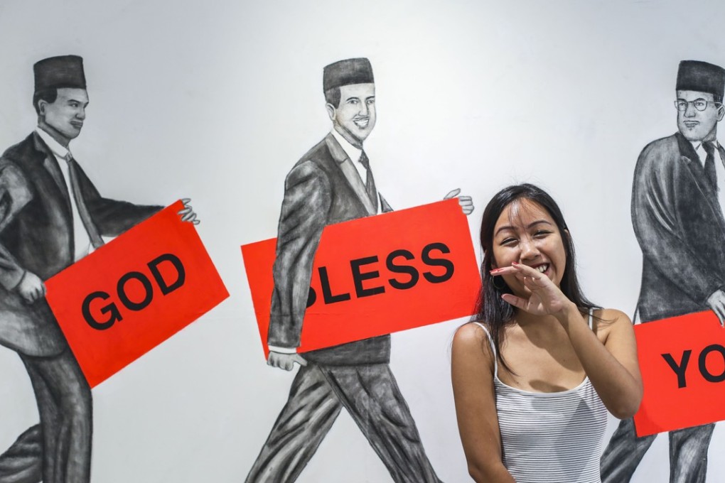 Malaysian artist Engku Iman poses in front of one of her works, portraying Muslim businessmen, at A2Z Art Gallery in Hong Kong. Photo: Xiaomei Chen