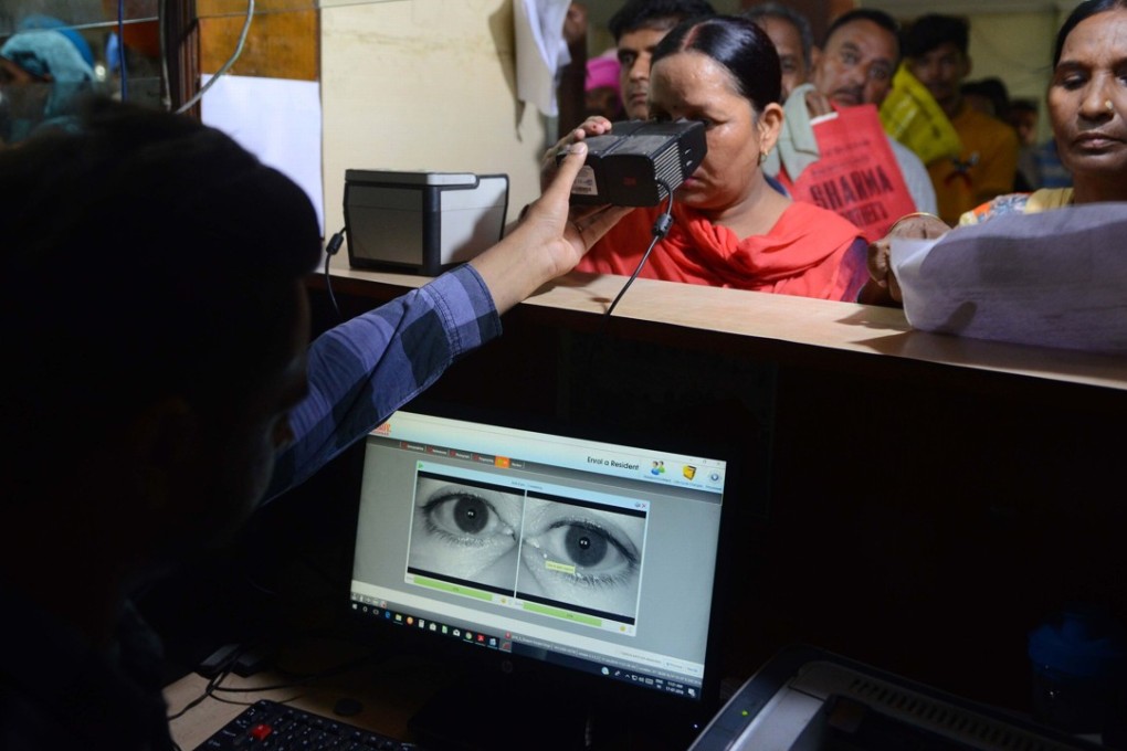 A woman looking through an optical biometric reader, which scans iris patterns, while registration for an Aadhaar card in Amritsar, India. Photo: AFP