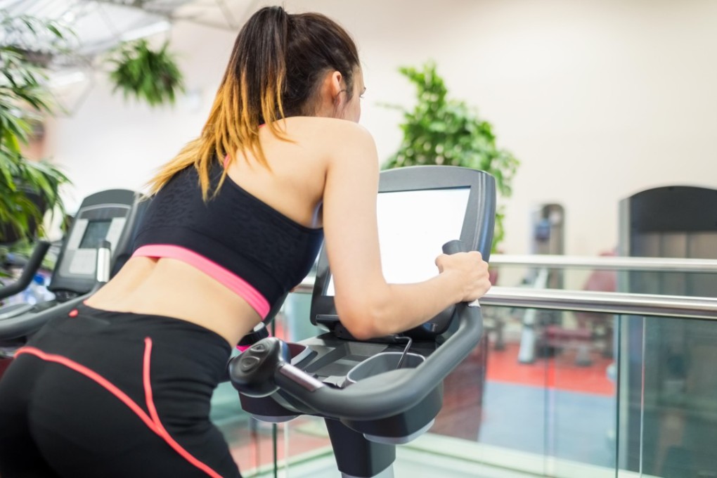 Watching TV while you work out may actually improve your exercise habits. Photo: Alamy