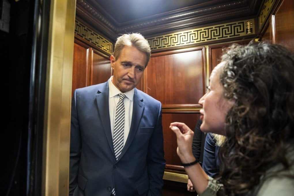 Ana Maria Archila confronts Republican Senator Jeff Flake in an lift after Flake announced that he vote to confirm Supreme Court nominee Brett Kavanaugh. Photo: EPA