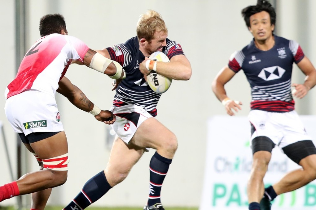 Hong Kong’s Toby Fenn tries to fight off Japan’s Jose Seru. Photos: Asia Rugby