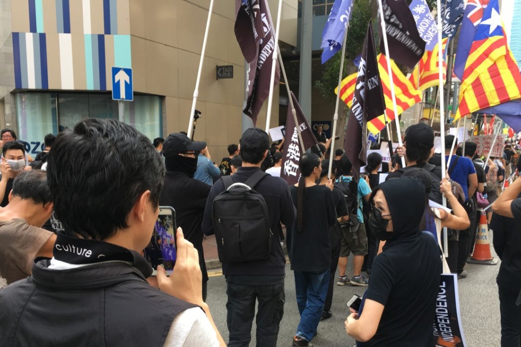 Police officers film pro-independence marchers carrying the Catalan flag. Photo: Alvin Lum