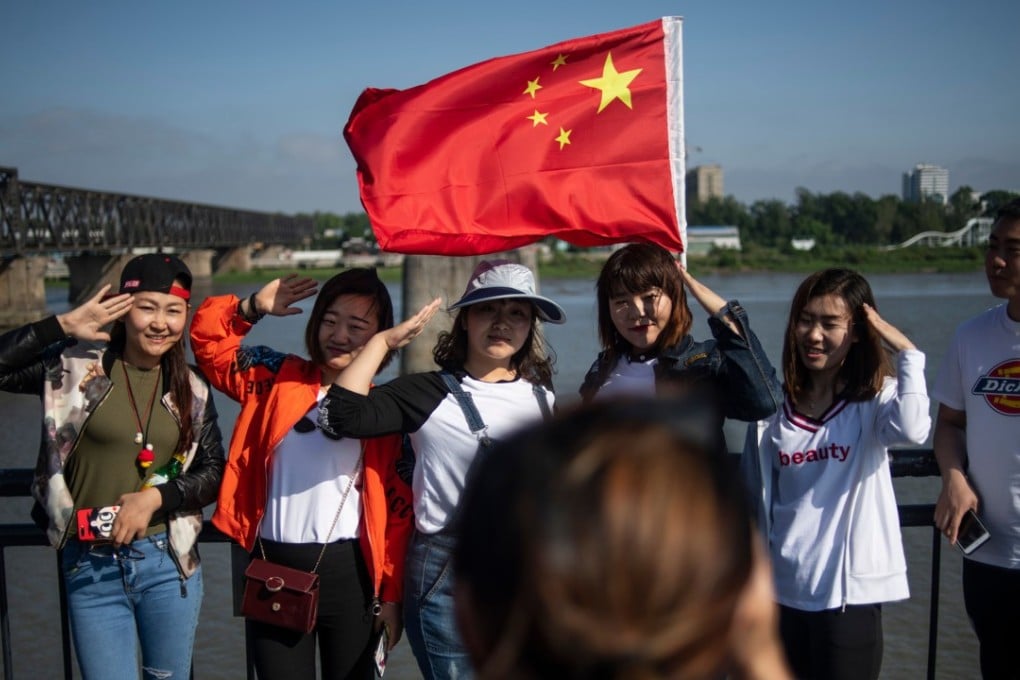 Chinese tourists taking pictures on the Broken Bridge in the border city of Dandong in Liaoning province. Photo: AFP