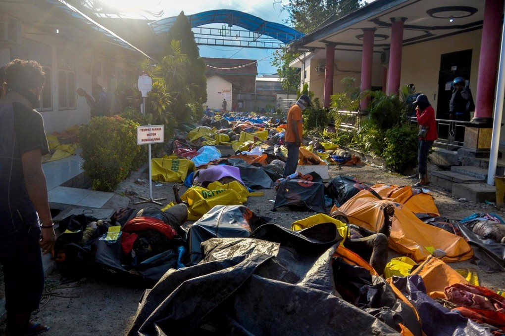 epa07059427 Relatives look for tsunami and earthquake victims in body bags at a police station, in the aftermath of earthquake in Palu, Indonesia, 30 September 2018. According to reports, at least 832 people have died as a result of a series of powerful earthquakes that hit central Sulawesi on 28 September 2018 and triggered a tsunami. EPA-EFE/STR