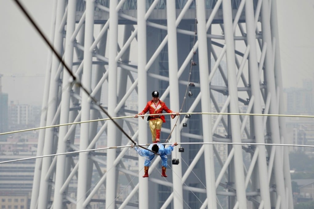 This feat by tightrope walkers 100m above the Pearl River in Guangzhou is nothing compared to the difficult balancing act China needs to achieve between political centralisation and economic decentralisation. Photo: Xinhua
