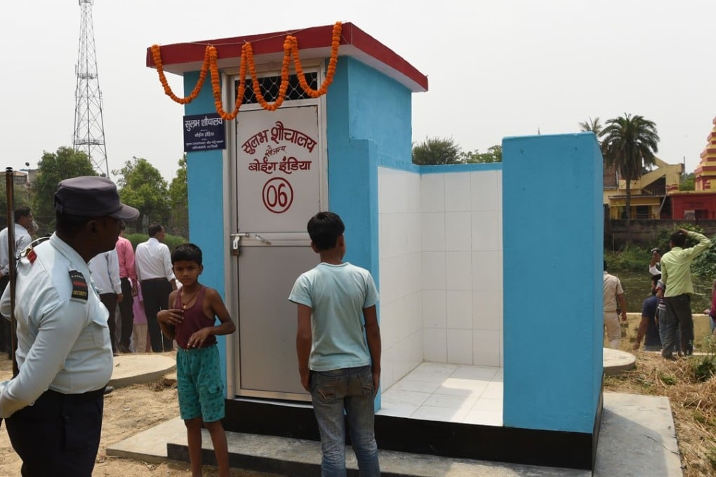 A security guard and villagers gather around a newly built public toilet at Sarisabpahi Village in Madhubani district. Photo: AFP