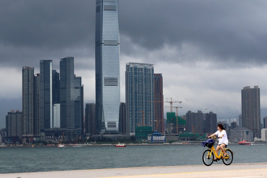A woman cycles on a pier in Western District as Tropical Storm Ewiniar approaches Hong Kong, on June 7. Photo: Dickson Lee