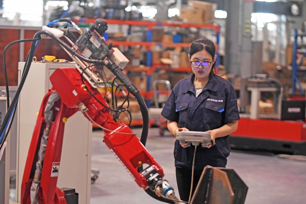 A worker adjusts a robotic arm at a Saisun workshop in Shenyang, capital of northeast China’s Liaoning province. Photo: Xinhua