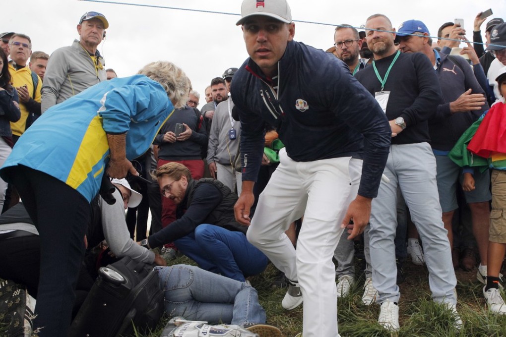Brooks Koepka checks on the spectator he wounded when his ball hit her on the sixth hole during his fourball match on the opening day of the Ryder Cup at Le Golf National. Photo: AP