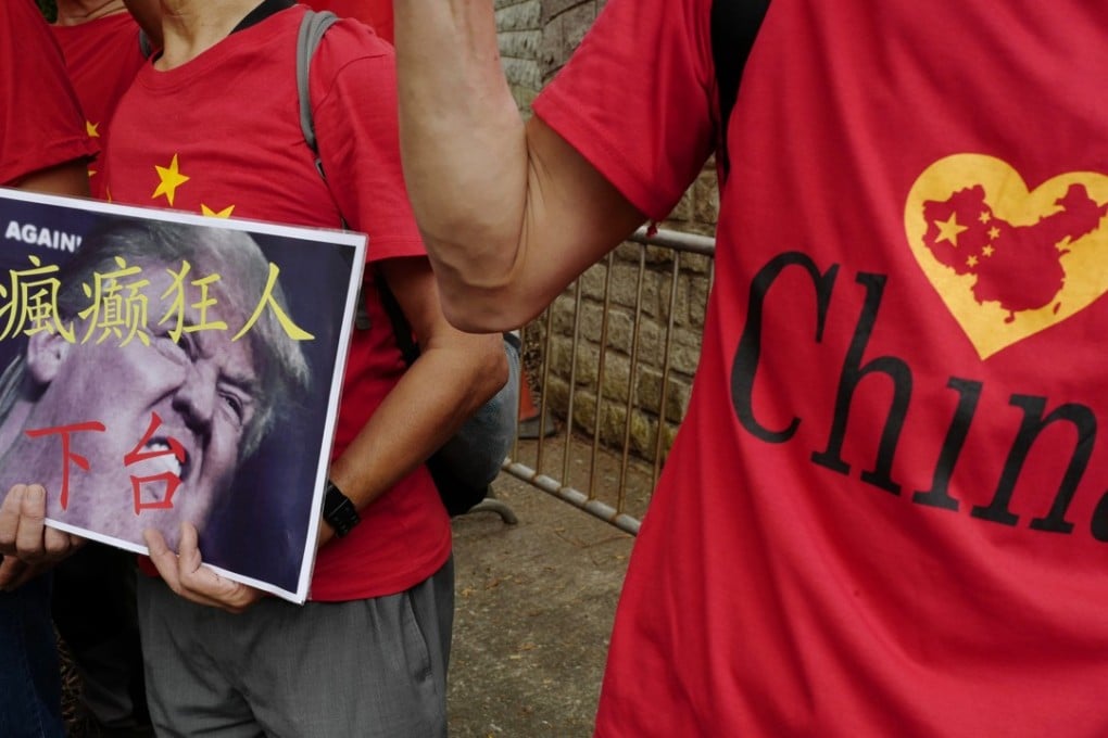 Pro-China protesters display a placard with the words “Crazy man step down” during a demonstration against US President Donald Trump's trade war on China, outside the US consulate in Hong Kong on October 1. Photo: AP