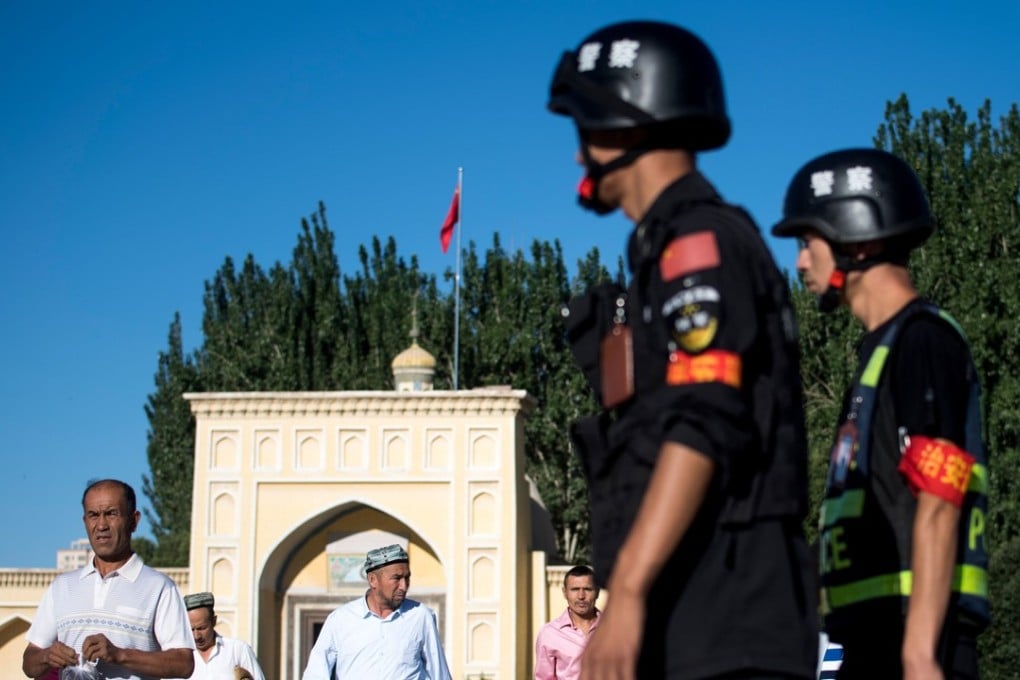 Chinese police patrol outside a mosque in Xinjiang as Muslims leave morning prayer in June 2017. Photo: AFP
