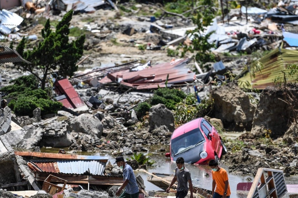 Residents walk through debris in Indonesia’s central Sulawesi, where dozens of students were pulled from a landslide-swamped church. Photo: AFP