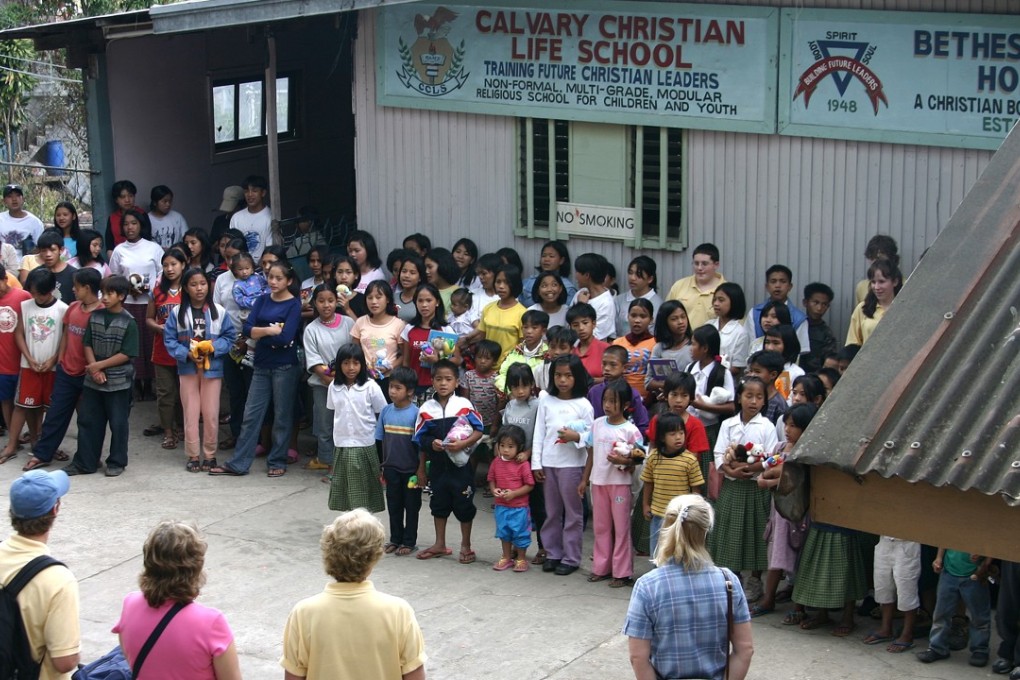 Western tourists visit an orphanage in the Philippines.