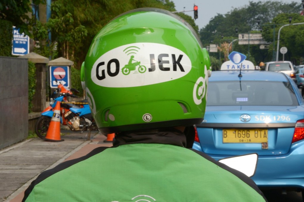 A motorcycle driver with Indonesian ride-hailing start-up Go-Jek waits for customers along a street in Jakarta. Photo: Agence France-Presse