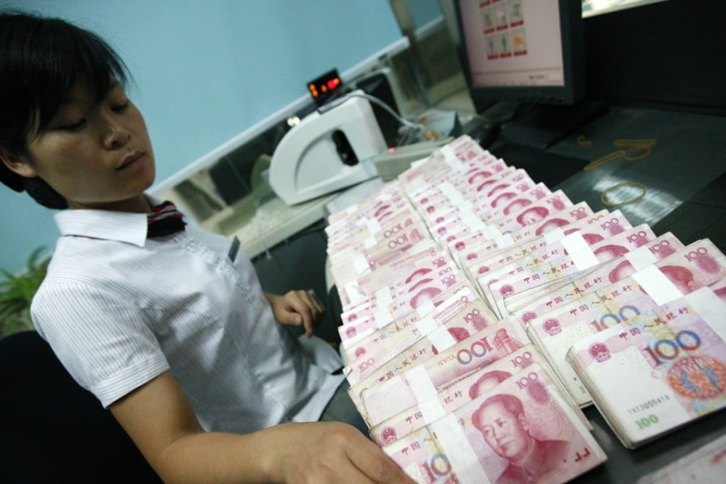 A Chinese bank clerk counts stacks of 100-yuan notes at a bank in Huaibei. Photo: AFP