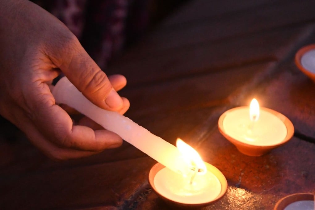 A Nepali youth activist lights candles during a vigil in memory of the victims of acid attacks in Kathmandu. Photo: AFP