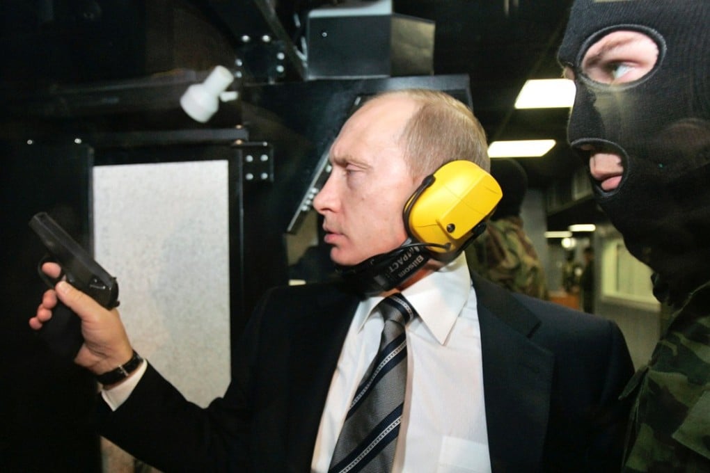 Russian President Vladimir Putin and a masked security officer at a shooting gallery in Moscow. Photo: Reuters