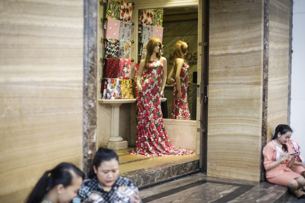 Indonesian sales personnel take a break outside a fashion store at a shopping area in Jakarta, Indonesia, 26 September 2018. EPA-EFE/MAST IRHAM
