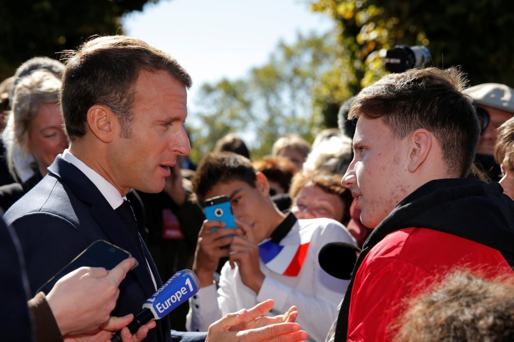 French President Emmanuel Macron talks with a youth as he walks in the streets of Colombey-les-Deux-Eglises to mark the 60th anniversary of the French Constitution. Photo: Reuters