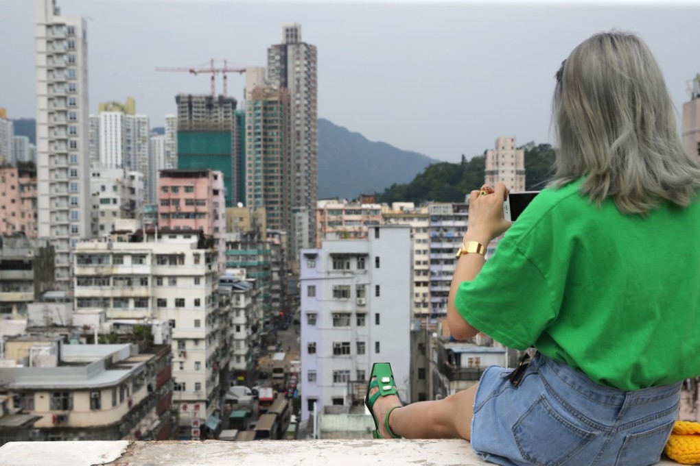 A woman sitting on a high-rise ledge in Hong Kong posing for a photo. Photo: Sam Tsang