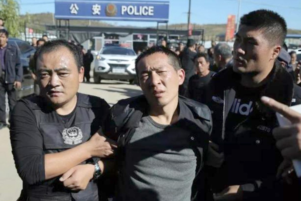 Zhang Guilin is escorted by police after his arrest. Photo: Sina.com