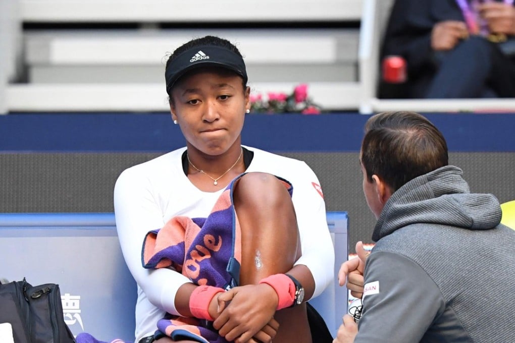 Naomi Osaka speaks with her coach during her semi-final against Anastasija Sevastova at the China Open in Beijing, during a match where she had treatment on her back. Photo: AFP