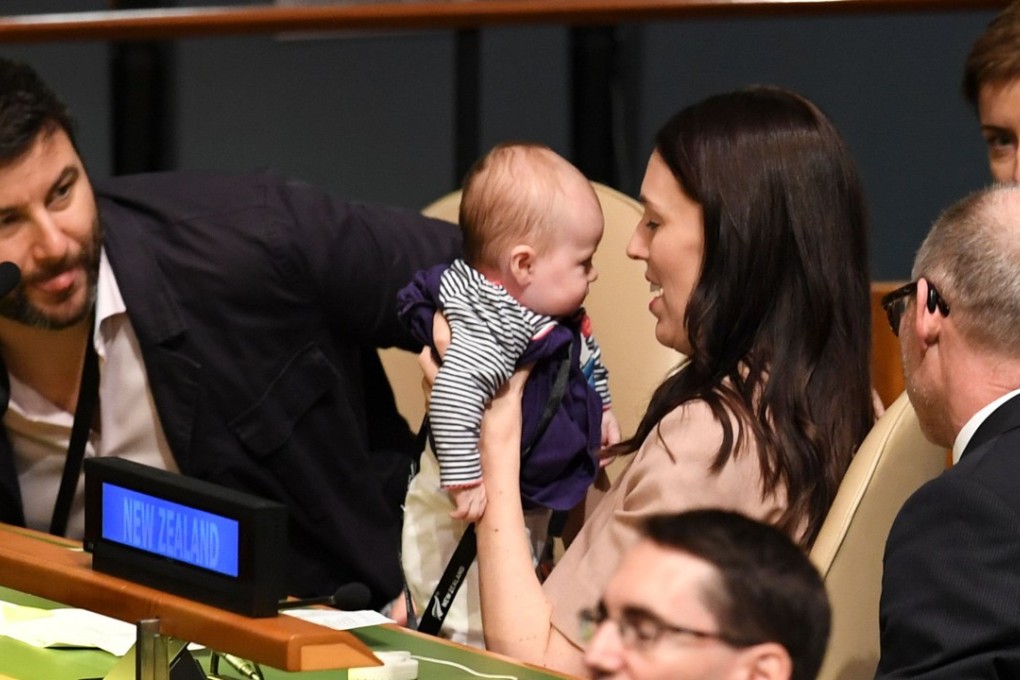 New Zealand Prime Minister Jacinda Ardern holds her daughter, Neve, as her husband, Clarke Gayford (left), looks on during the Nelson Mandela Peace Summit. Photo: AFP