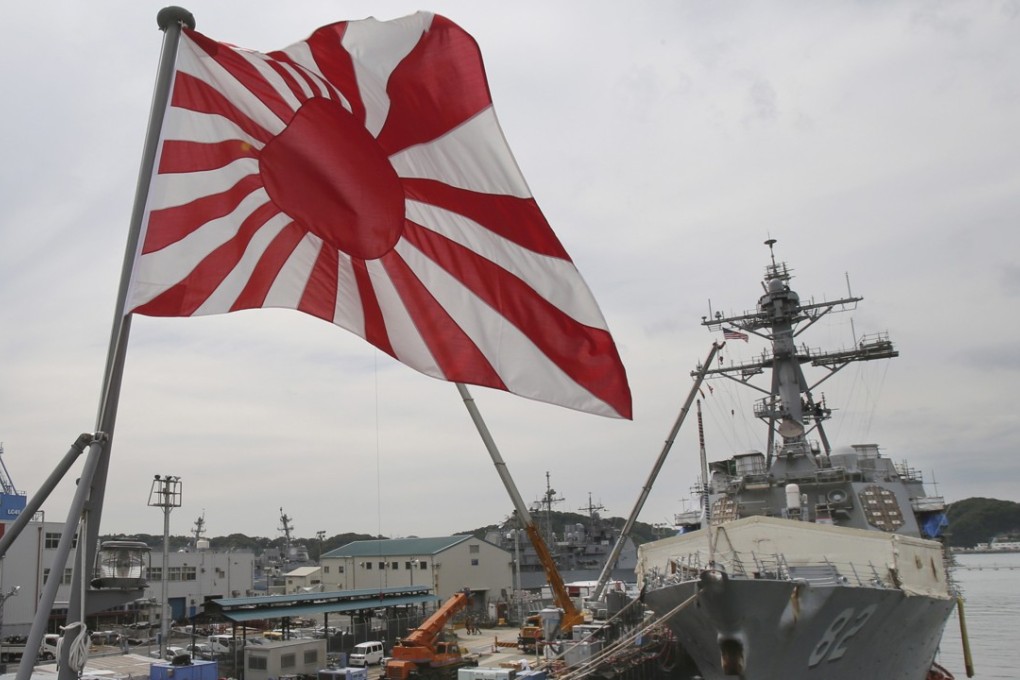 Japan's military flag, the Rising Sun Flag, flutters on the Japan Maritime Self-Defense Force tank landing ship JS Kunisaki anchored in Yokosuka near Tokyo. Photo: AP