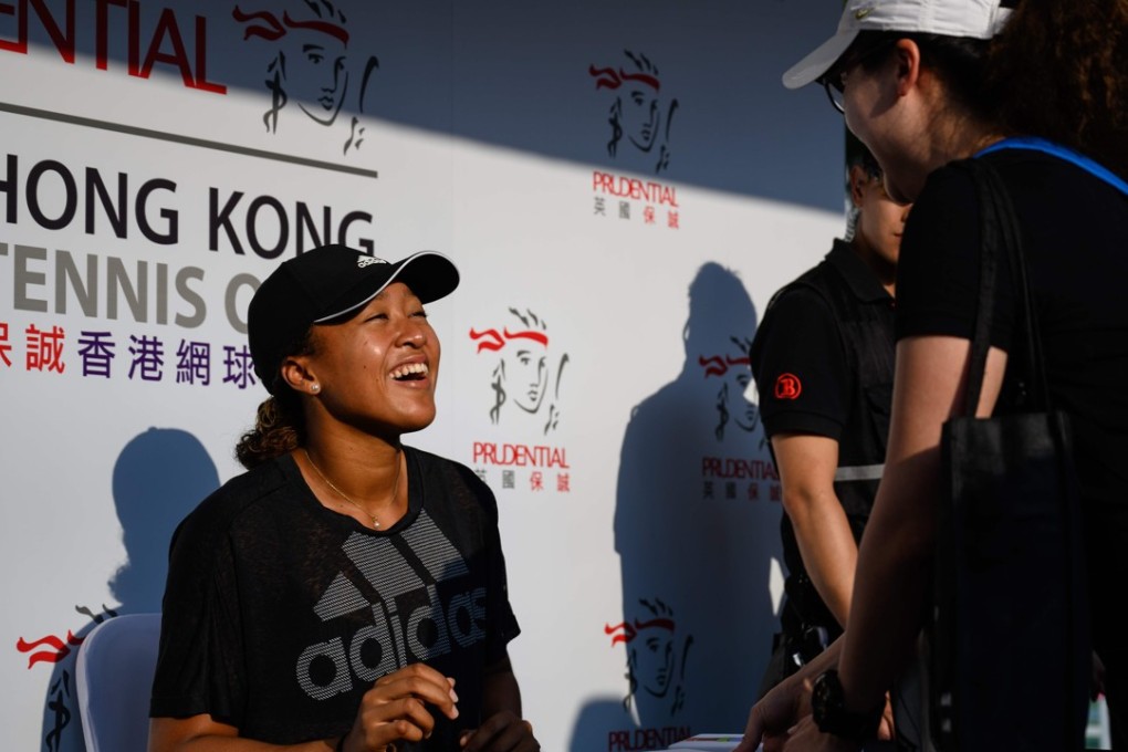 Naomi Osaka (left) smiles as she meets fans and signs autographs at the Hong Kong Open. Photo: AFP