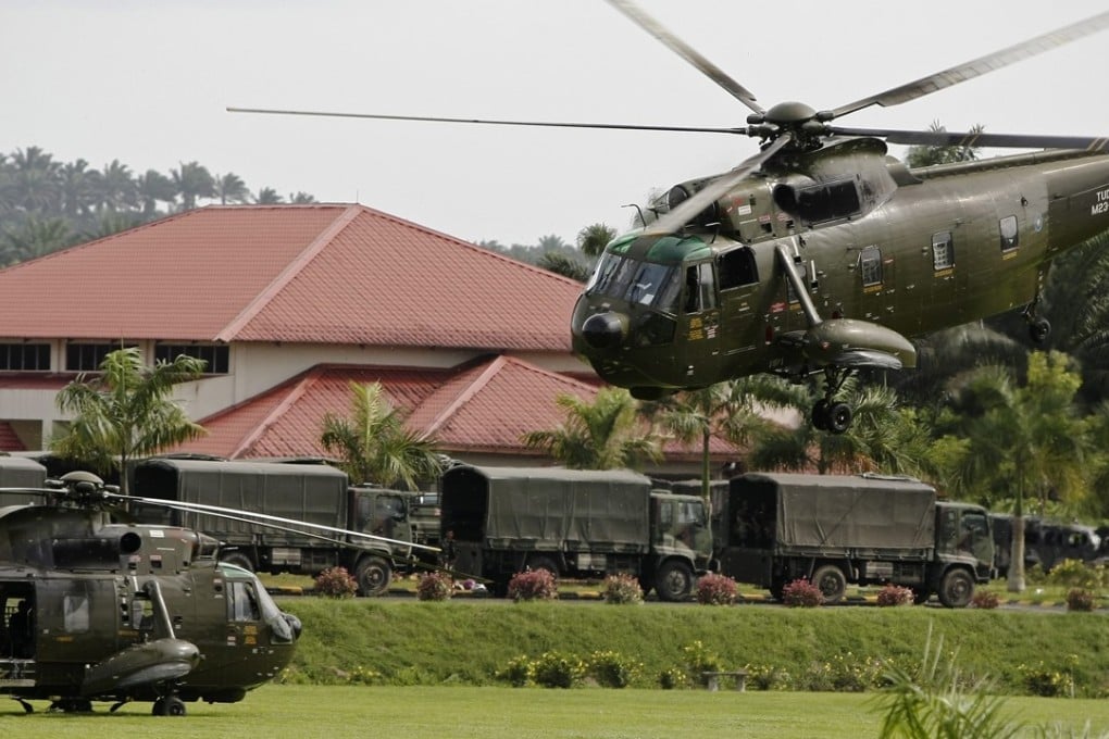 Malaysian army helicopters and vehicles at the temporary army base camp at Felda Sahabat near Lahad Datu. Photo: EPA