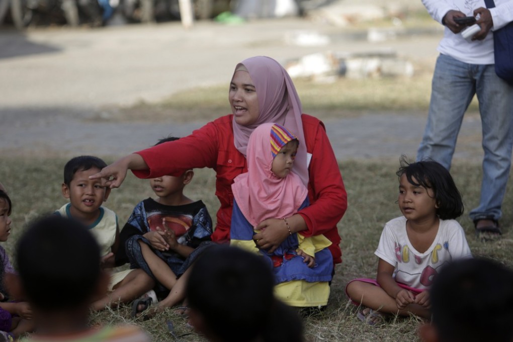 Group of displaced children play together as part of trauma healing session, an initiative provided by 'Save The Children' in Palu city. Many children went back to school on Monday, as schools tried to get an idea of how many would be returning to classrooms after the disaster. Photo: EPA