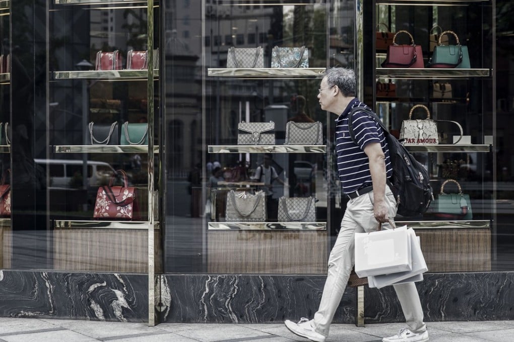 A pedestrian walks past a luxury store in Shanghai. China’s economy is slowing, and risks from the trade war with the US are not helping. Photo: Bloomberg