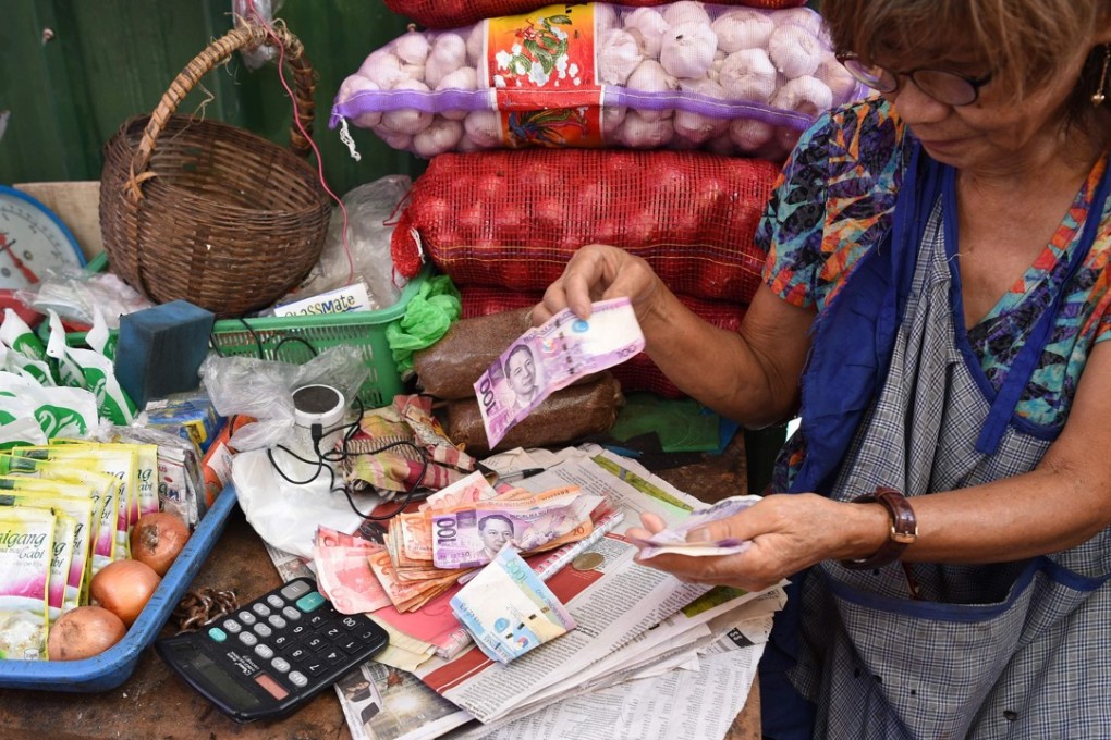 A vendor counts her earnings at a market in Manila – Philippine inflation rose for a ninth straight month in September, to a near-10-year high. Photo: AFP