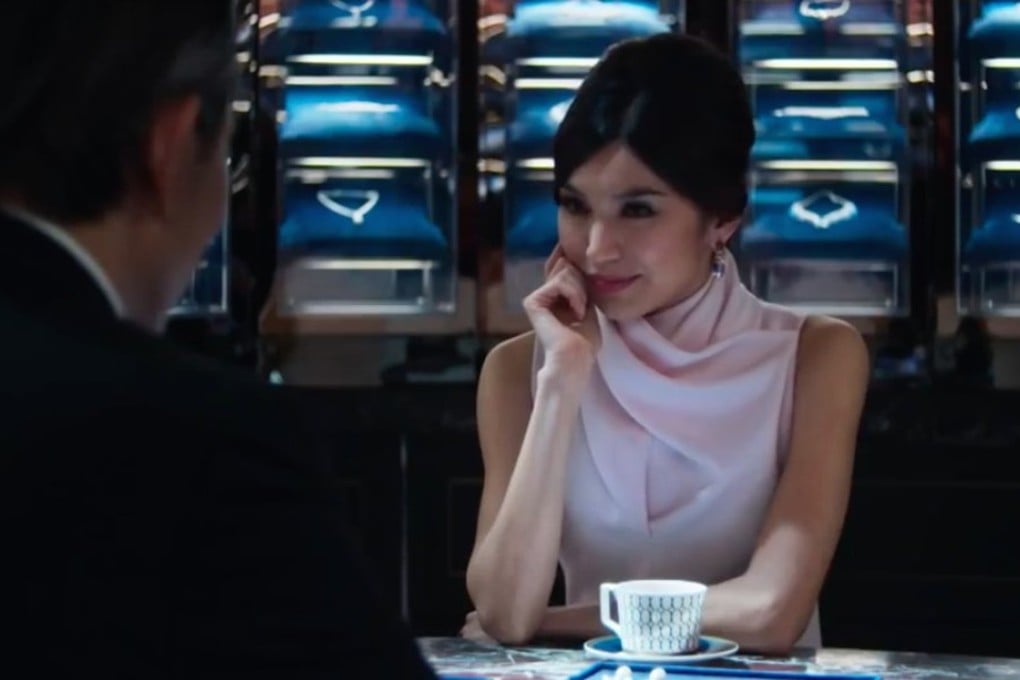In this still from Crazy Rich Asians, Astrid (Gemma Chan) buys a pair of stunning pearl drop gem-encrusted earrings made by Mouawad.