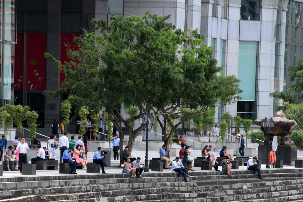 Office workers sit along the river during lunch break in the financial district of Raffles Place in Singapore on February 19, 2018. Singapore tops the World Bank’s new human capital list. Photo: AFP