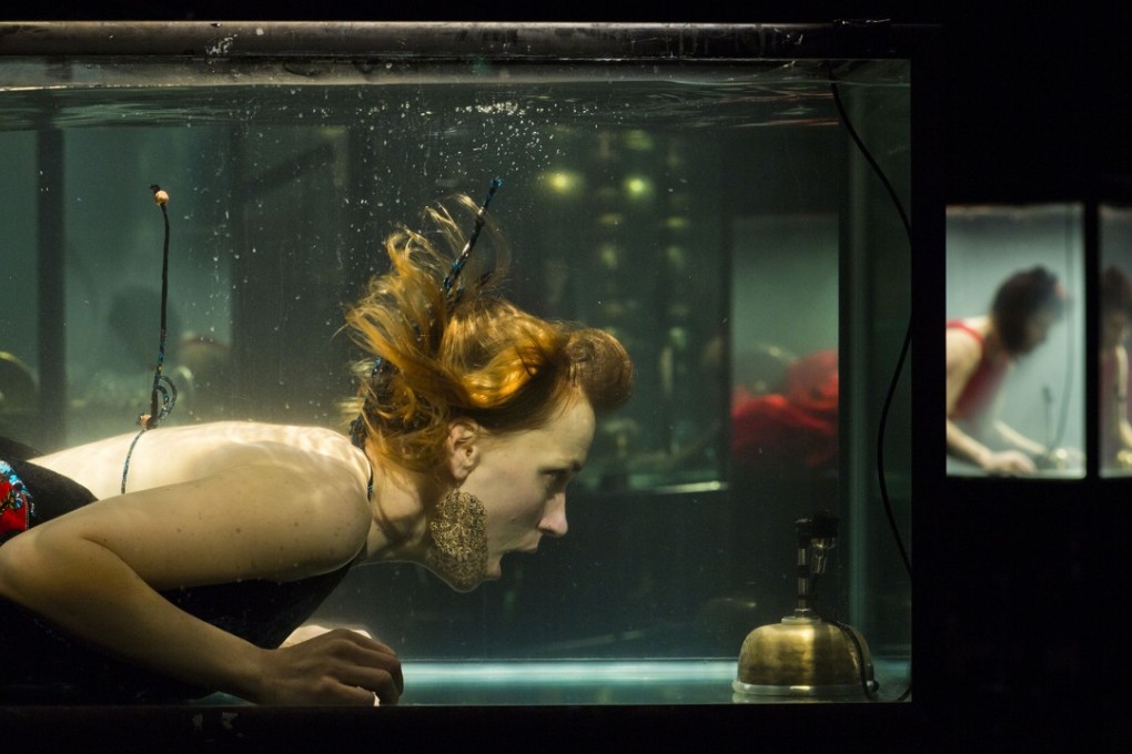Musicians are submerged in individual glass tanks for AquaSonic, an underwater concert by Between Music.