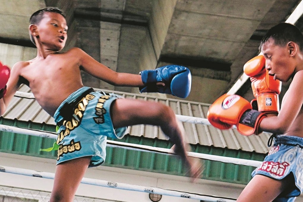 Twin brothers Jirasak and Pornsak Katsriphuak, who are 10 years old, duke it out during a Muay Thai training session. Photo: Tibor Krausz