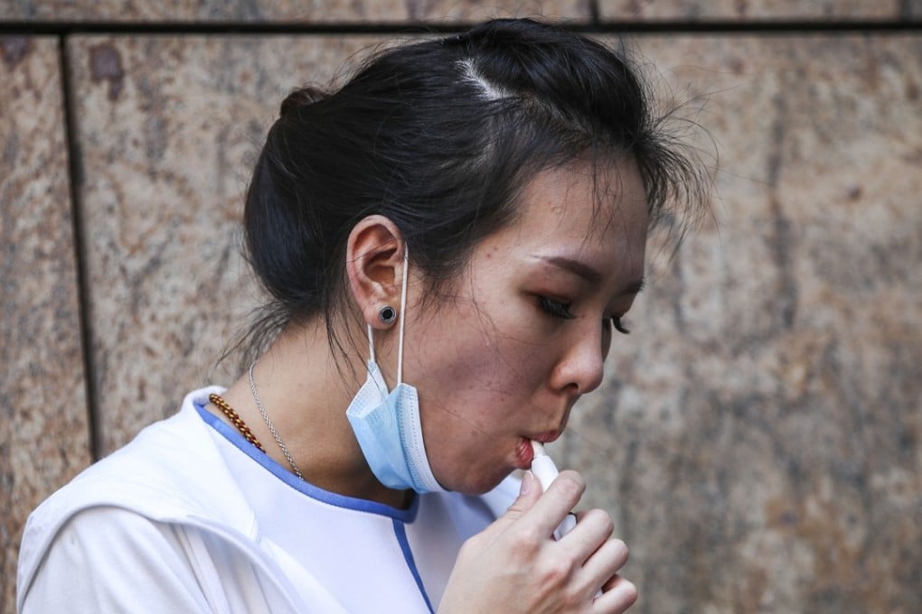 A woman smokes an electronic cigarette in Mong Kok. If Hong Kong goes ahead with its ban on e-cigarettes, it will join more than a dozen other countries that have done the same. Photo: Edward Wong