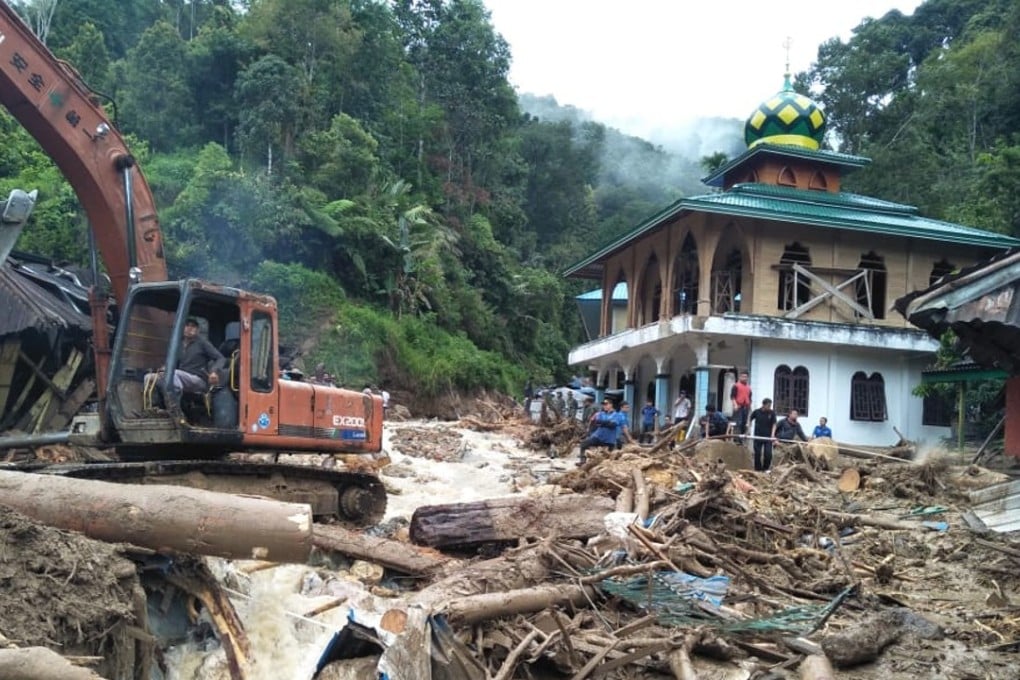 People use a heavy equipment to remove debris after flash floods hit the Saladi village in Mandailing Natal, North Sumatra. Photo: AFP